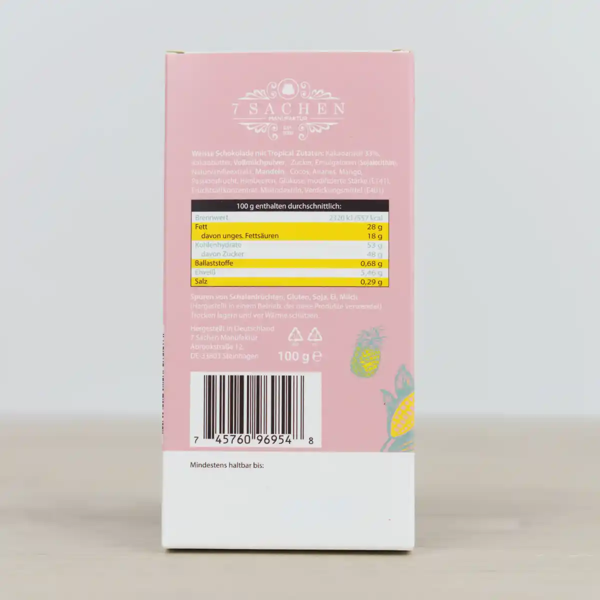 Handgegossene weiße Schokolade mit Mandeln, Cocos, Ananas, Mango & Himbeerperlen – cremig & raffiniert aus Steinhagen. Rückseite