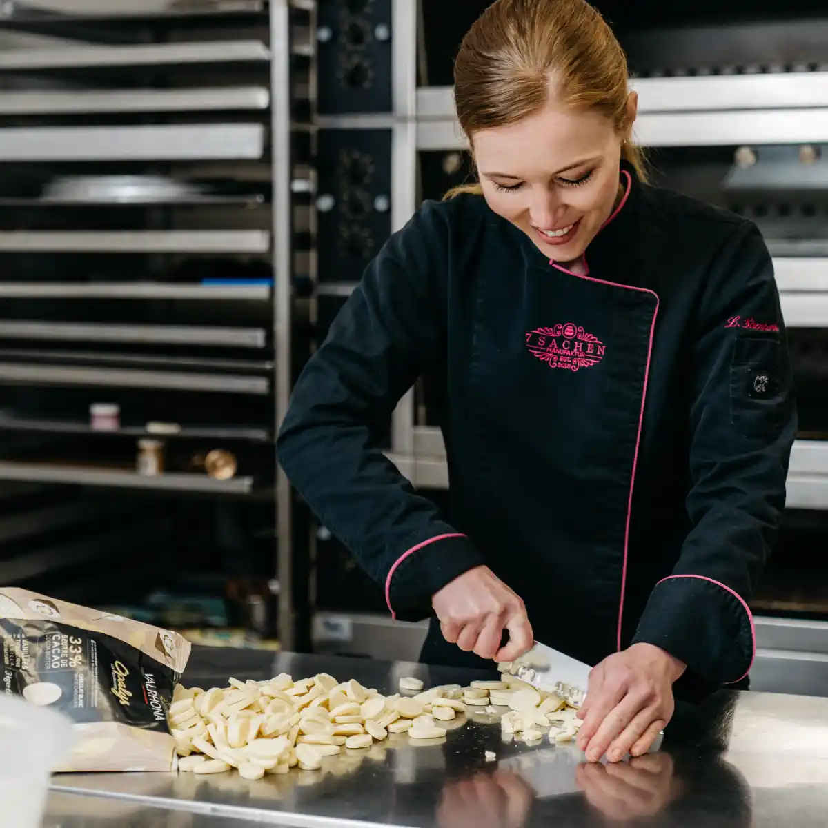 Konditormeisterin Luise Strothenke zerkleinert weiße Schokolade in ihrer Manufaktur in Steinhagen – Handarbeit mit Herz