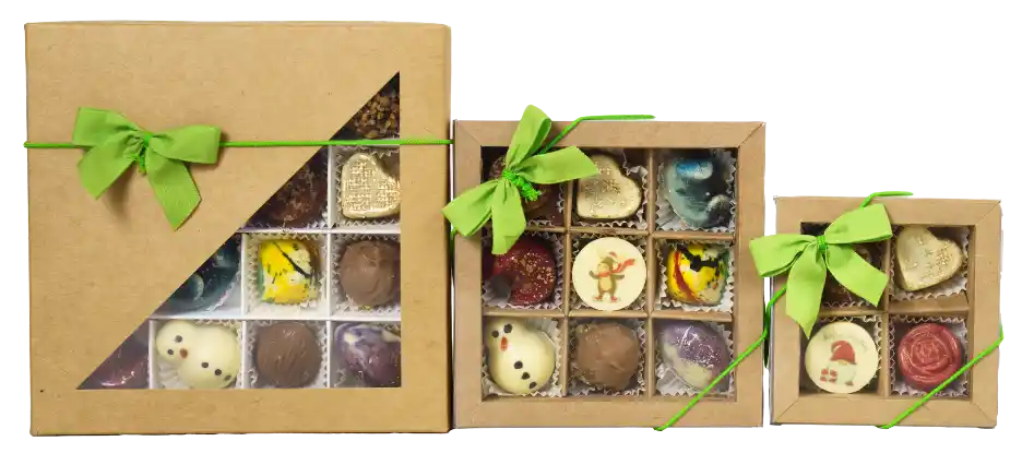Drei Verpackungsgrößen handgefertigter Pralinen aus der 7 Sachen Manufaktur in Steinhagen mit grüner Schleife